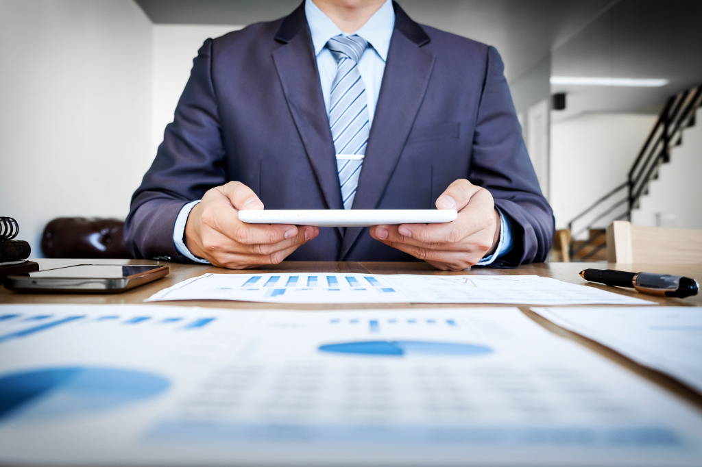 multitasking-handsome-young-man-working-with-touchpad-while-sitting-couch-office-financial-statistic-graph.jpg преобразование АО в ООО